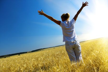 Woman in wheaten field and beautiful sunsetの写真素材