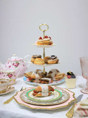 Table set up for tea party, focus on a small sandwich on the vintage plateの写真素材