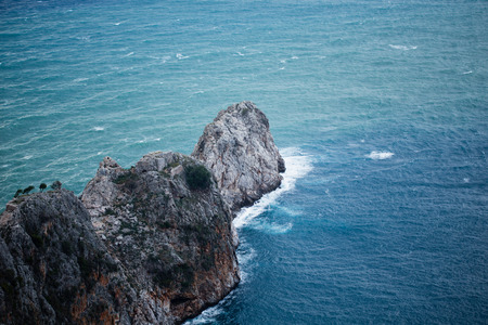 steep slopes of cape Jilvarda southern part of Alanya castle rock with remains of old monastery turquoise sea and wavesの写真素材
