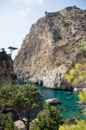 Beautiful Delik Deniz sea bay with pristine waters and  remains of medieval castle on top of rock in Guney koyu village of Gazipasha Alanya Turkey near historical site Antiochia ad Cragum.の写真素材