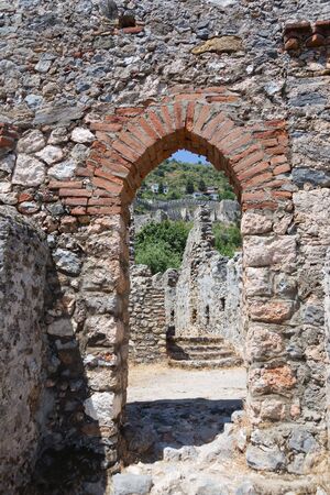Potrait layout of medieval castle wall of Alanya with arch from which remaining part of wall going uphill is visibleの写真素材
