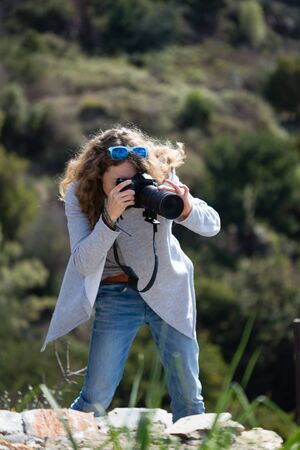 Blond photographer woman in gray jacket and jeans portrait layoutの写真素材