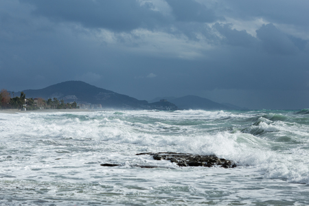 Powerful waves heating cost of mediterranean Turkey in Alanya with mountains on background shot on cloudy dayの写真素材