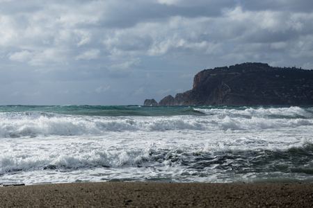 Seascape showing powerful waves heating coast of Alanya shot on cloudy day landscape layoutの写真素材