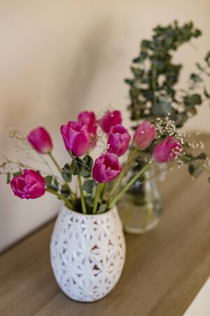 bouquet of pink tulips with tulips in sharp focus and decoratory eucalyptus blurred on backgroundの写真素材