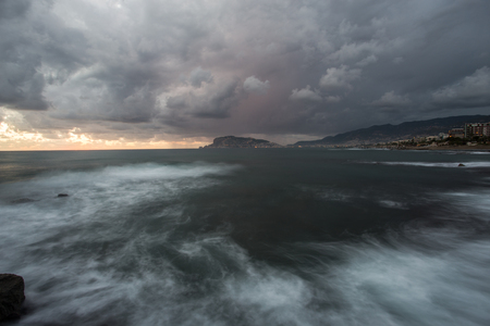 Long exposure sunset seascape and cityscape of Alanya in Turkey with dramatic cloudsの写真素材