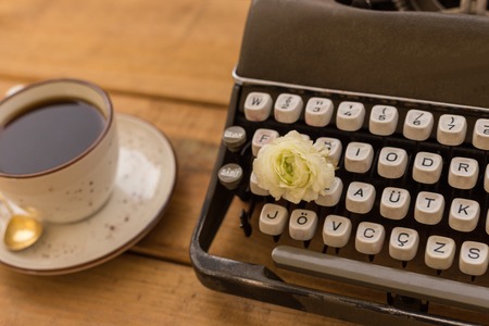 Writing in spring concept. Retro typewriter with white ranunculus among the keysの写真素材