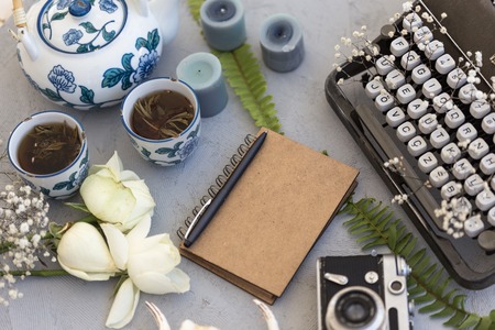 Spring or summer writing and freelance concept. Styled workdesk with retro typewriter, notepad,...