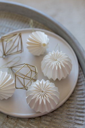 Table centerpiece with white origami decorations in white plateの写真素材