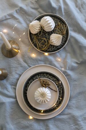 Upper view shot of Christmas table setting with black and white stoneware placed over light gray washed linen tableclothの写真素材