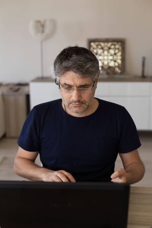 Middle age man working from home using his laptop