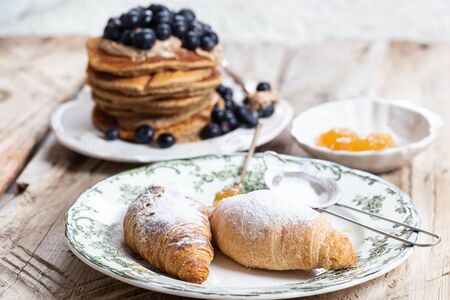 Croissants on a white plate with green ornamentの写真素材