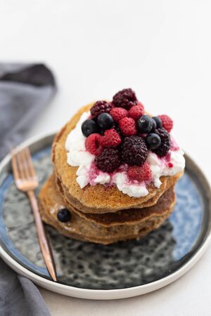 Stack of oatmeal pancakes topped with hazelnut paste and blueberの写真素材