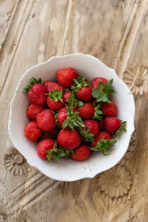 Topview image of strawberries in a white rustic bowlの写真素材
