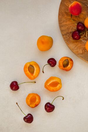 Topview image of apricots and cherries on light gray tabletopの写真素材