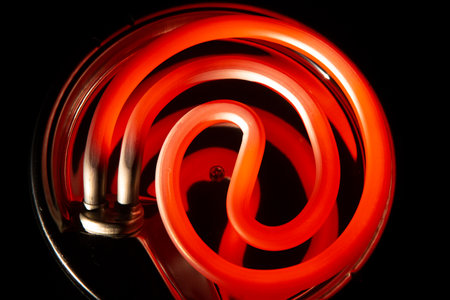 Red hot electric stove on a dark background