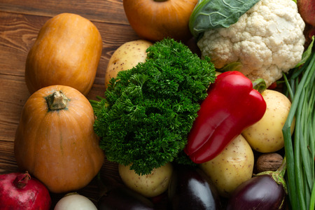 Vegetables and nuts on a brown wooden backgroundの写真素材