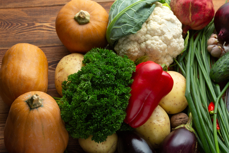 Vegetables and nuts on a brown wooden backgroundの写真素材