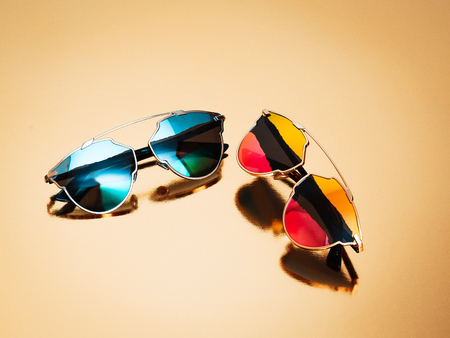 Glasses A few elite Sunglasses with a colorful lenses on a gold backgroundの写真素材
