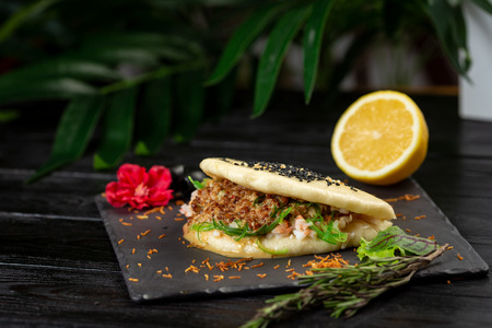 bao with lamb on a black plate on a wooden backgroundの写真素材