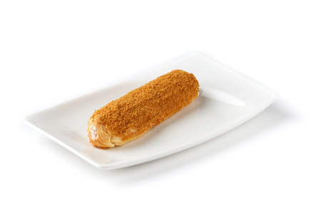 classic eclair on a white rectangular plate on an isolated white background