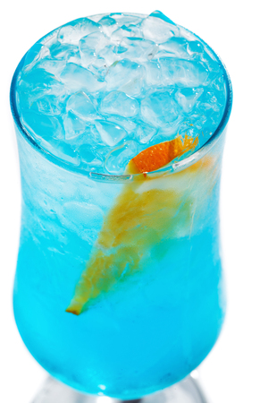 blue cocktail with ice and orange in a tall glass on an isolated white background close-upの写真素材