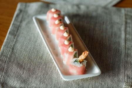 set of tuna rolls on a rectangular plateon a gray napkinの写真素材
