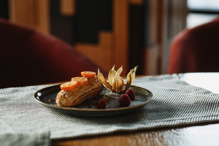 eclair cake on a plate decorated with citrus on a gray backgroundの写真素材