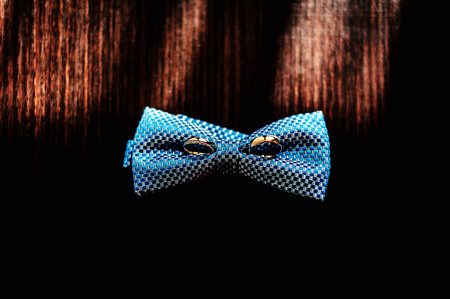 Wedding rings on the groom's butterfly on the dark wooden tableの写真素材