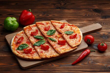 pizza with tomatoes, mozzarella and tartar sauce on a brown wooden background