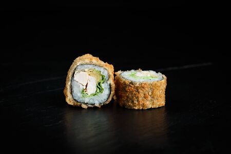 pair of sushi tempura rolls close-up on a dark backgroundの写真素材