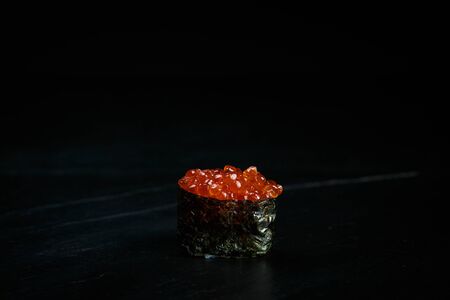 japanese cuisine single gunkan ikura on a black backgroundの写真素材