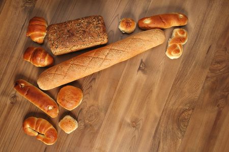 Different types of breads on wooden background