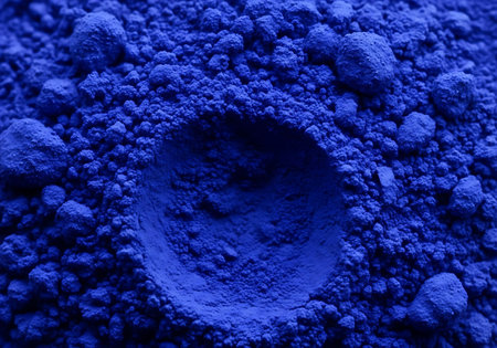 A close-up view of finely ground ultramarine blue pigment powder, showcasing its intense color and granular texture with a distinct circular indentation.の素材