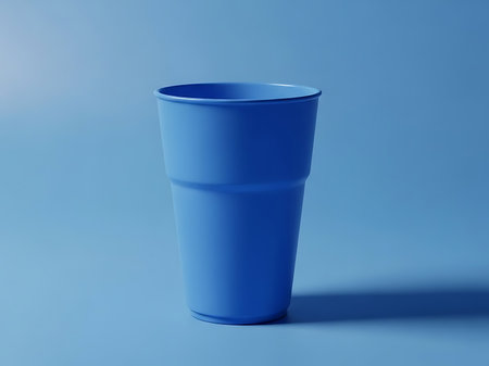 A simple and clean image of a blue plastic cup against a matching blue background The shot is well lit and the subject is in focus The monochromatic palette gives the image a minimalist feel and makes it ideal for use in a variety of creative projectsの素材