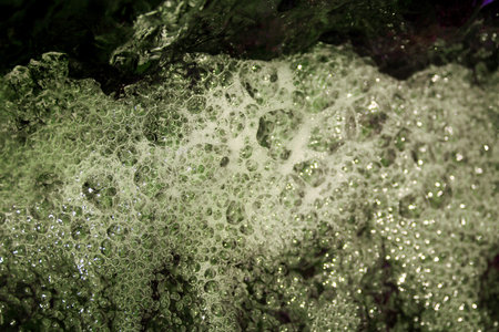 Conceptual retouched and colored image of polluted sewage spewing out with bubbles and splashes due...