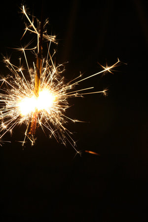 Japanese local tradition toy fireworks SENKO HANABI sparkling in front of black background.