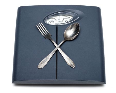 Bathroom scales, fork and spoon isolated on whiteの写真素材