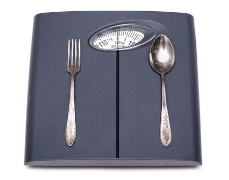 Bathroom scales, fork and spoon isolated on whiteの写真素材