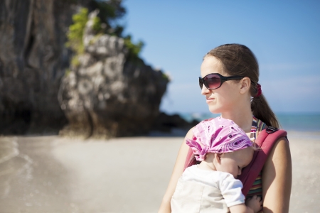 Young woman with baby at the beachの写真素材