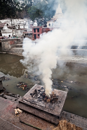 KATHMANDU - APRIL 15: Cremation ceremony along the holy Bagmati River at Pashupatinath Temple complex, April 15, 2012 in Kathmandu, Nepal. This is the most sacred place to all Hindus in Nepal.のeditorial素材