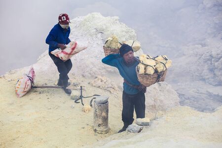 BANYUWANGI, INDONESIA - OCTOBER 27, 2014: Unidentified Sulfur miners inside crater Ijen volcano crater, Banyuwangi district, Indonesia.のeditorial素材