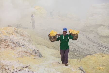 BANYUWANGI, INDONESIA - OCTOBER 27, 2014: Unidentified Sulfur miner inside crater of Ijen volcano, East Java, Indonesia.のeditorial素材