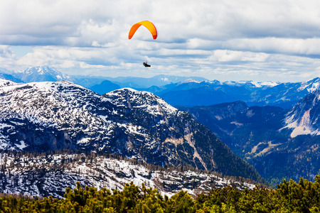 Paraglider in the Dachstein Alps Mountains in Salzkammergut region, Austria view from Five Fingers...