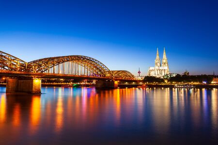 Cologne Cathedral and Hohenzollern Bridge through Rhine river in Cologne, Germanyの写真素材