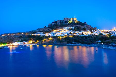Lindos Acropolis and beach aerial panoramic view in Rhodes island in Greece at nightの写真素材
