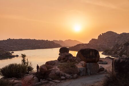 Mountain with boulders and river at Hampi, the centre of the Hindu Vijayanagara Empire in Karnataka...