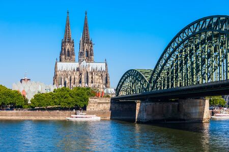 Cologne Cathedral and Hohenzollern Bridge through Rhine river in Cologne, Germanyの写真素材