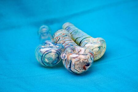 Glass pipe or bong for marijuana smoking on a blue fabric backgroundの写真素材