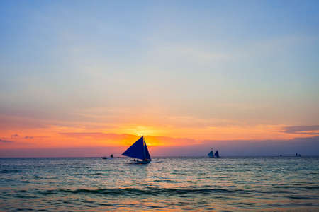 Traditional filipino boat at the idyllic white sand beach at Boracay island in Philiphines at sunset